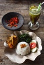 Fried chicken rice, vegetables, spicy chili sauce and avocado juice on a wooden table Royalty Free Stock Photo