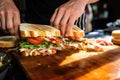 hands serving portions of sliced grilled sandwich