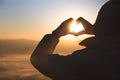 Hands in shape of love heart, Female hands in the form of heart against the sky pass sun beams. Happy in love