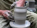 Hands shaping clay on potter's wheel