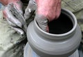 Hands shaping clay on potter's wheel