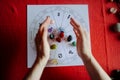 Young woman hands throwing group of colorful crystal stones during tarot reading with red background Royalty Free Stock Photo