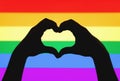 Hands showing heart sign on gay pride and LGBT rainbow flag Royalty Free Stock Photo