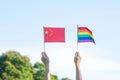 Hands showing LGBTQ Rainbow and China flag on nature background. Support Lesbian, Gay, Bisexual, Transgender and Queer community Royalty Free Stock Photo