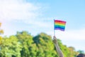 Hands showing LGBTQ Rainbow flag on nature background. Support Lesbian, Gay, Bisexual, Transgender and Queer community and Pride Royalty Free Stock Photo