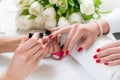 Hands of a skilled manicurist applying red nail polish on the na Royalty Free Stock Photo