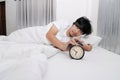 Hands of sleepless and desperate young man turns off the alarm clock waking up at morning Royalty Free Stock Photo