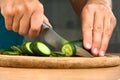 Hands slicing cucumber on the cutting board Royalty Free Stock Photo