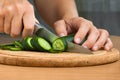 Hands slicing cucumber for salad, closeup Royalty Free Stock Photo