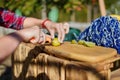 Hands slicing fresh lime on wooden cutting board for outdoor party coctails or beverages. Royalty Free Stock Photo