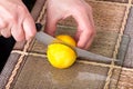 Hands slicing lemon with knife. Royalty Free Stock Photo