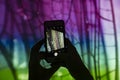 Hands with a smartphone taking picture of screen projection with macro picture of dragonfly wings