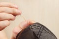 Hands of snipper sew black cotton clothes with needle close up Royalty Free Stock Photo