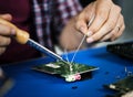 Hands soldering tin on electronics circuit board Royalty Free Stock Photo