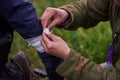 Hands of a soldier bandaging a wounded soldier`s hand