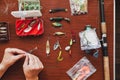 Hands of spinning arm attach leash to bait on table Royalty Free Stock Photo