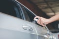 Hands spraying alcohol on car door handle,Preventive measures against coronavirus,Covid-19 pandemic Royalty Free Stock Photo