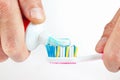 Hands squeezing color toothpaste from a tube on toothbrush Royalty Free Stock Photo