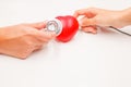 Hands with stethoscope and charging cable to check and cure heart on white background. Heart disease protection, proactive checkup