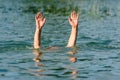 Hands stick out of the water to represent a drowning person.