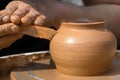 Hands of a street potter make a clay pot on a potter`s wheel. Royalty Free Stock Photo