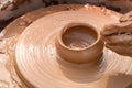 Hands of a street potter make a clay pot on a potter`s wheel. Royalty Free Stock Photo