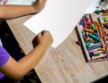 Hands of student holding crayon draw and painting on white paper