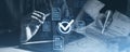 Hands with stylus reviewing documents, digital checkmarks overlay. Blue-toned style, business evaluation concept