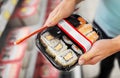 Hands with sushi pack at grocery or supermarket