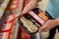 Hands with sushi pack at grocery or supermarket