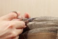 Hands of tailor with a pair of scissors cut strong cloth close up