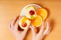 Hands take gourmet cream cake cookie and orange Royalty Free Stock Photo