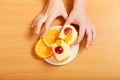 Hands take gourmet cream cake cookie and orange Royalty Free Stock Photo