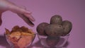 Hands with take potato chips from a deep plate. Unhealthy food, fast food