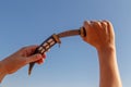 Hands taking a dagger with sky background Royalty Free Stock Photo