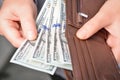 Hands taking out one hundred dollar bills from a leather wallet. Close-up front view Royalty Free Stock Photo