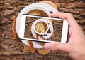 Hands taking photo coffee cup with smartphone.