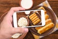 Hands taking photo pancakes with cottage cheese with smartphone.