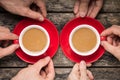 Hands Taking Two Red Cups of Coffee on old Wood Background Royalty Free Stock Photo