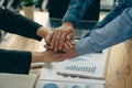 The hands of a team of businessmen joining forces celebrate the concept of unity. A close-up photo of a team working