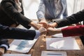 The hands of a team of businessmen joining forces celebrate the concept of unity. A close-up photo of a team working