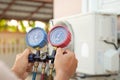 Hands of technician are using a measuring tool to check Vacuum pump evacuates air Royalty Free Stock Photo