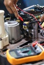 Hands of a technician using a multimeter to check the wiring and solenoid Royalty Free Stock Photo