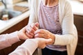 Hands of teenage girl and her grandmother at home. Royalty Free Stock Photo