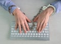 Hands of teenagers on computer keyboard in handcuffs Royalty Free Stock Photo