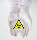 Hands with test sample and boihazard caution sign