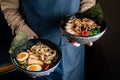 Hands of Thai Chef with delicious soup with noodles and pork of restaurant traditional Thai food.