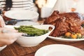 Hands, thanksgiving turkey or green beans food on dining table in holiday celebration, social gathering or lunch party