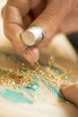 Hands and thimble doing embroidery with gold thread Royalty Free Stock Photo