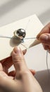 Hands threading a needle with white thread Royalty Free Stock Photo